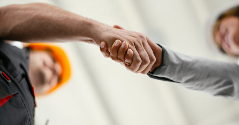 Close up of factory worker shaking hands