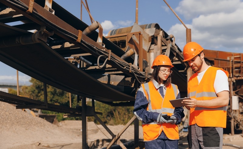 Technicians inspect outdoor conveyor belt