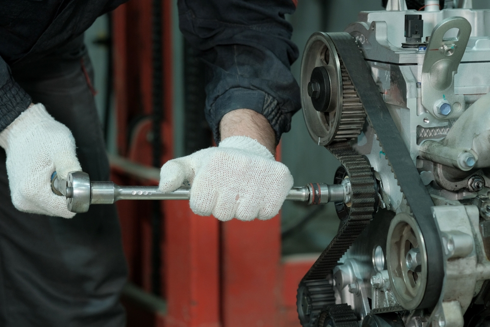 Technician repairing a belt drive system