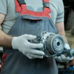 gearbox-gear-reducer Technician in gloves holds a faulty gearbox with gear reducers.