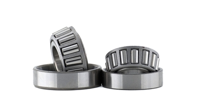 Set of new tapered roller bearings featuring rollers, cages, and races, isolated on a clean white studio background, highlighting precision engineering and shiny metal components