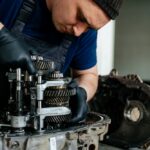 Young technician repairs gearbox for power transmission system.