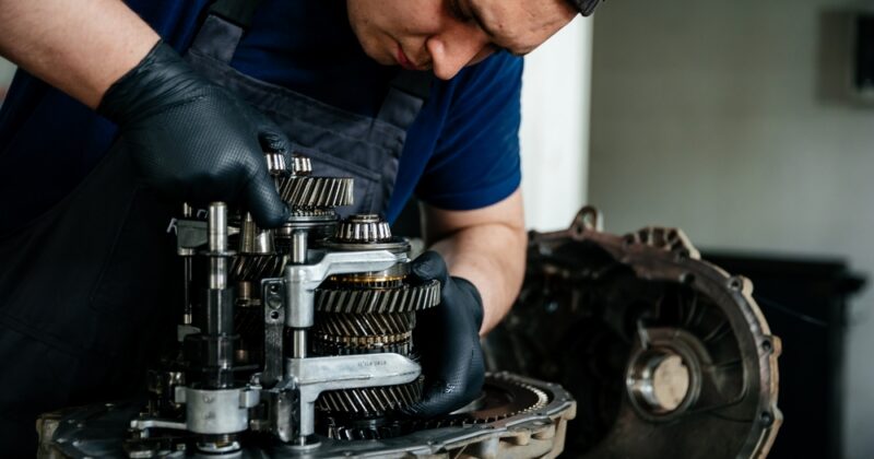 Young technician repairs gearbox for power transmission system.