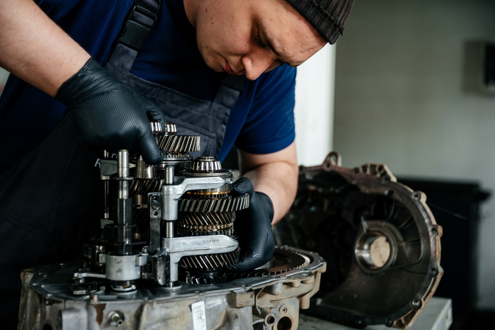Young technician repairs gearbox for power transmission system.